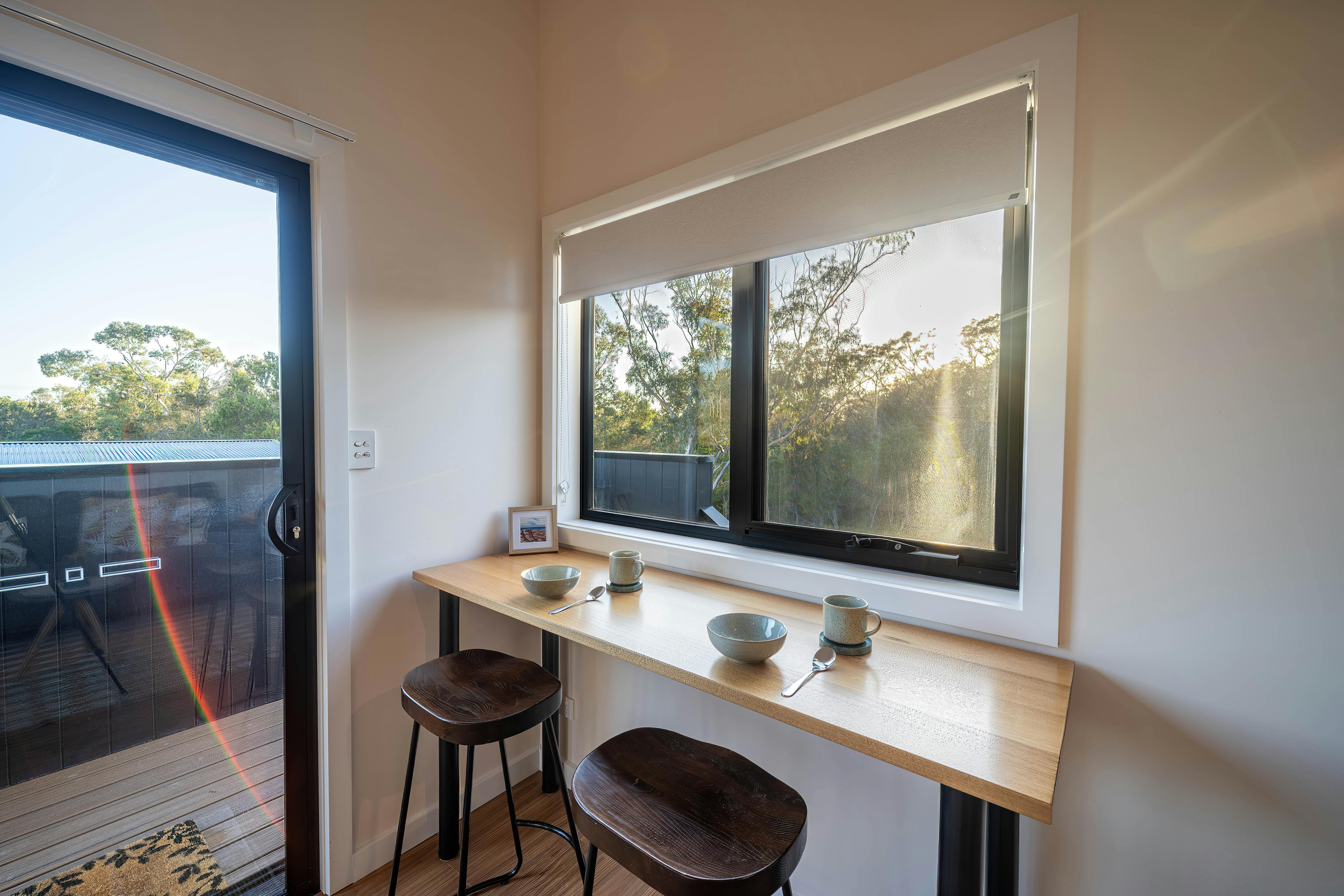 A bench with chairs at the base of a window