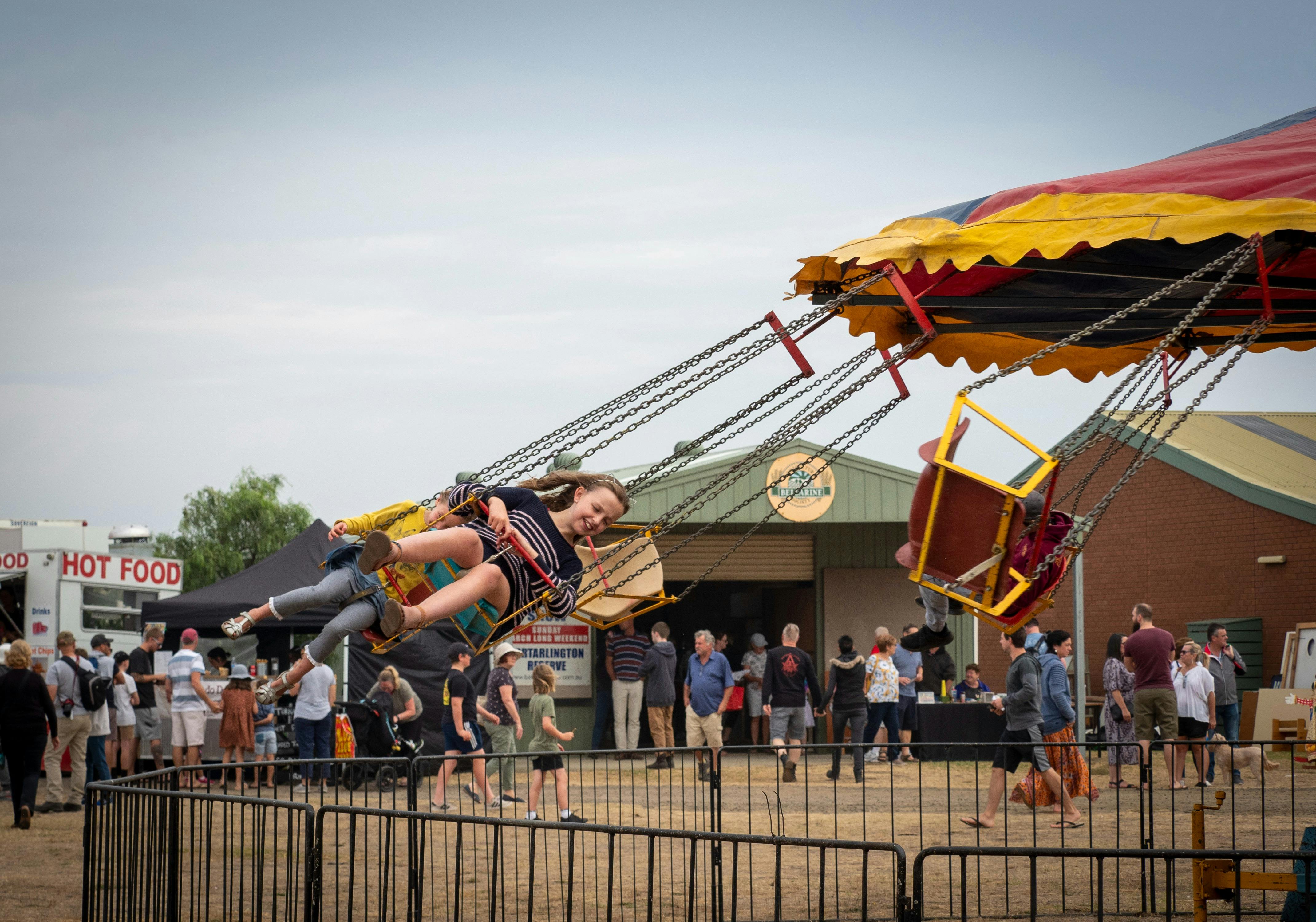 Children enjoying a colourful carnival swing ride at the Bellarine Agricultural Show.