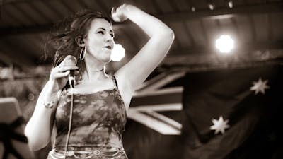 Female vocalist with Australian flag in background
