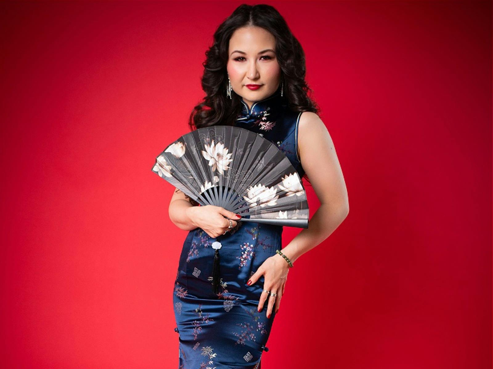 Portrait of astist with fan on red background