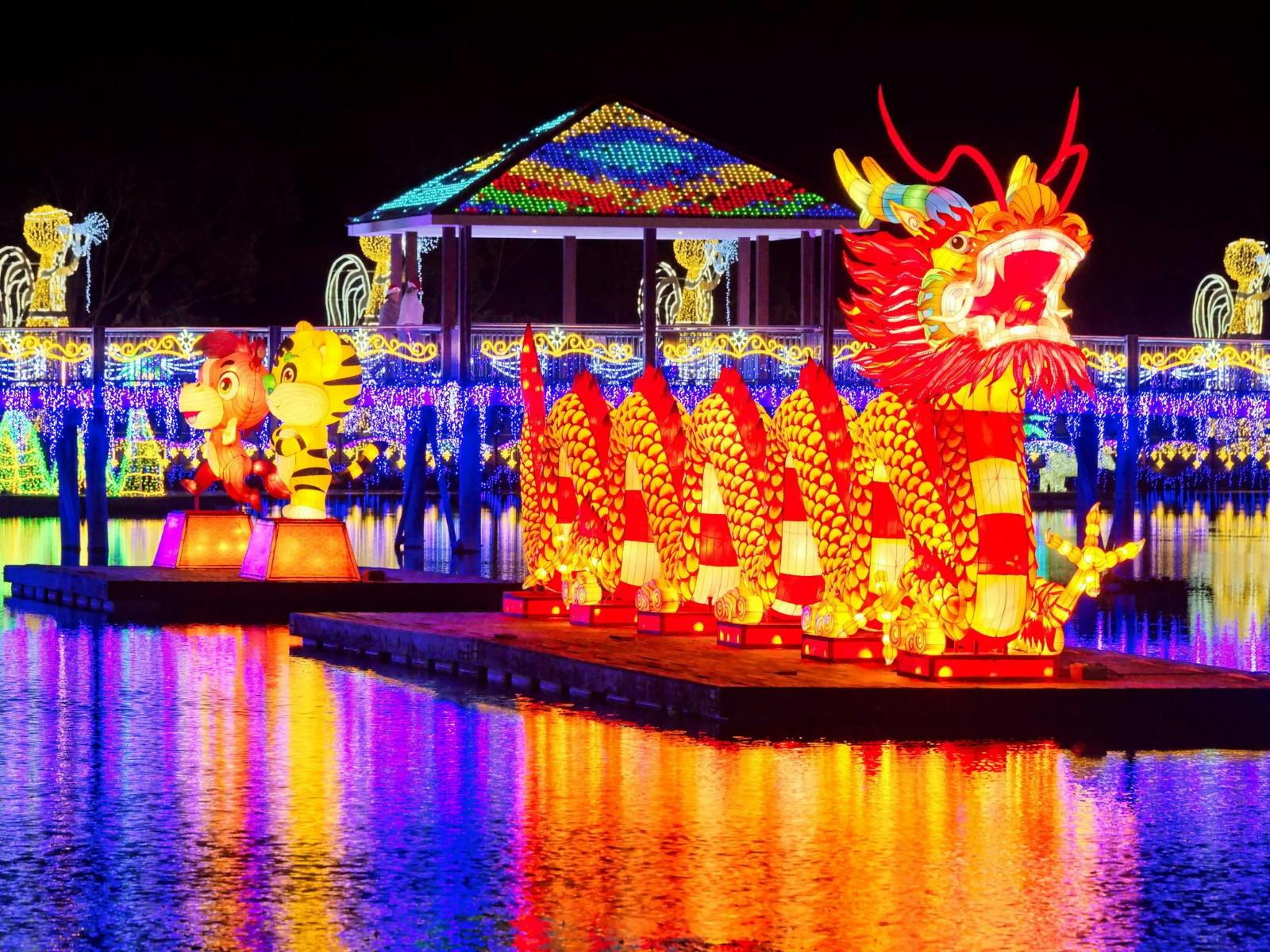 A floating Chinese dragon latern on a lake at night time
