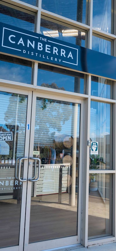 The Canberra Distillery shopfront with two men approaching