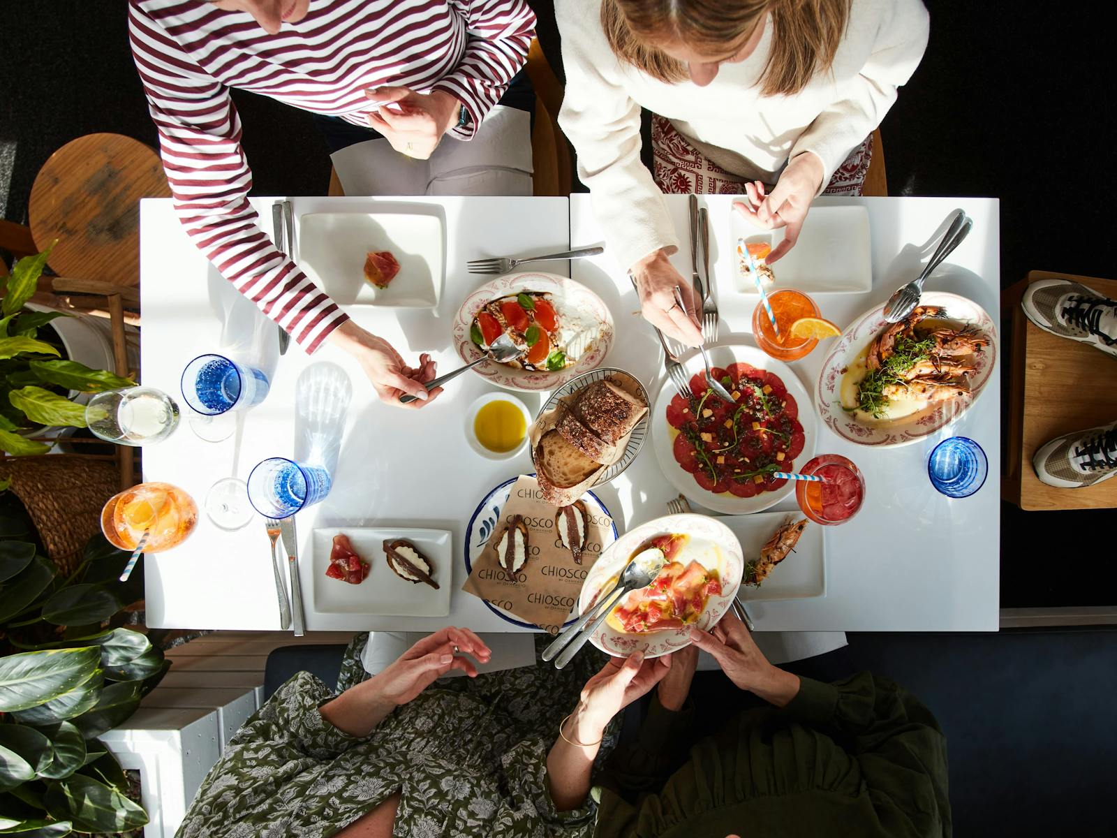 A table full of various dishes for sharig at Chiosco, with guests helping themselves
