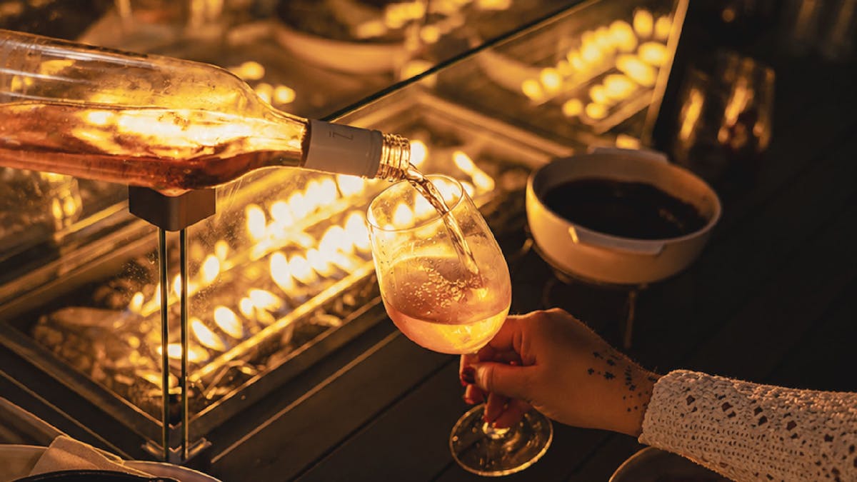 A firepit table with free-flowing wine and a chocolate fondue