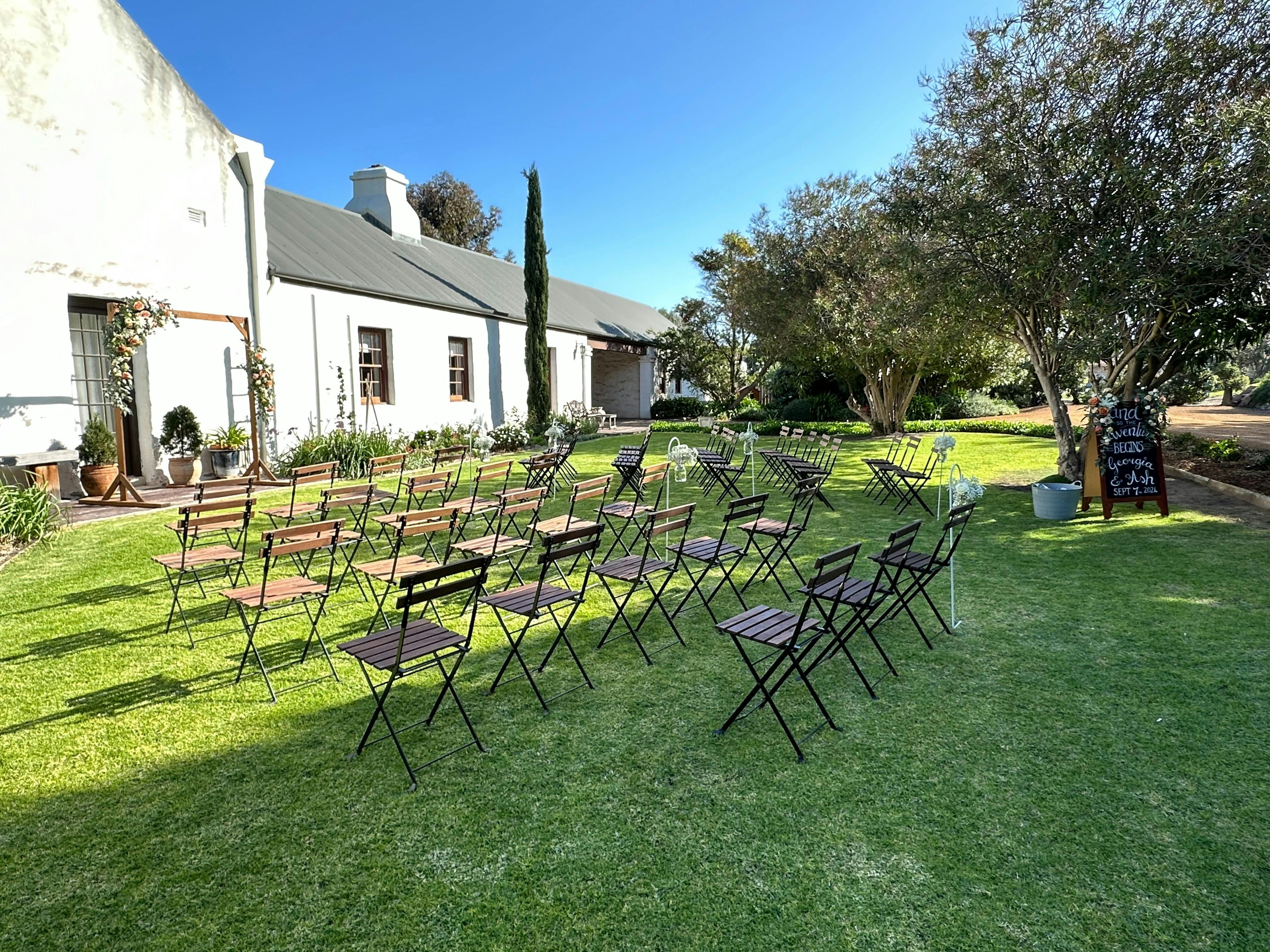Dempster Homestead Wedding set up with hire chairs, arbour, hooks and signage