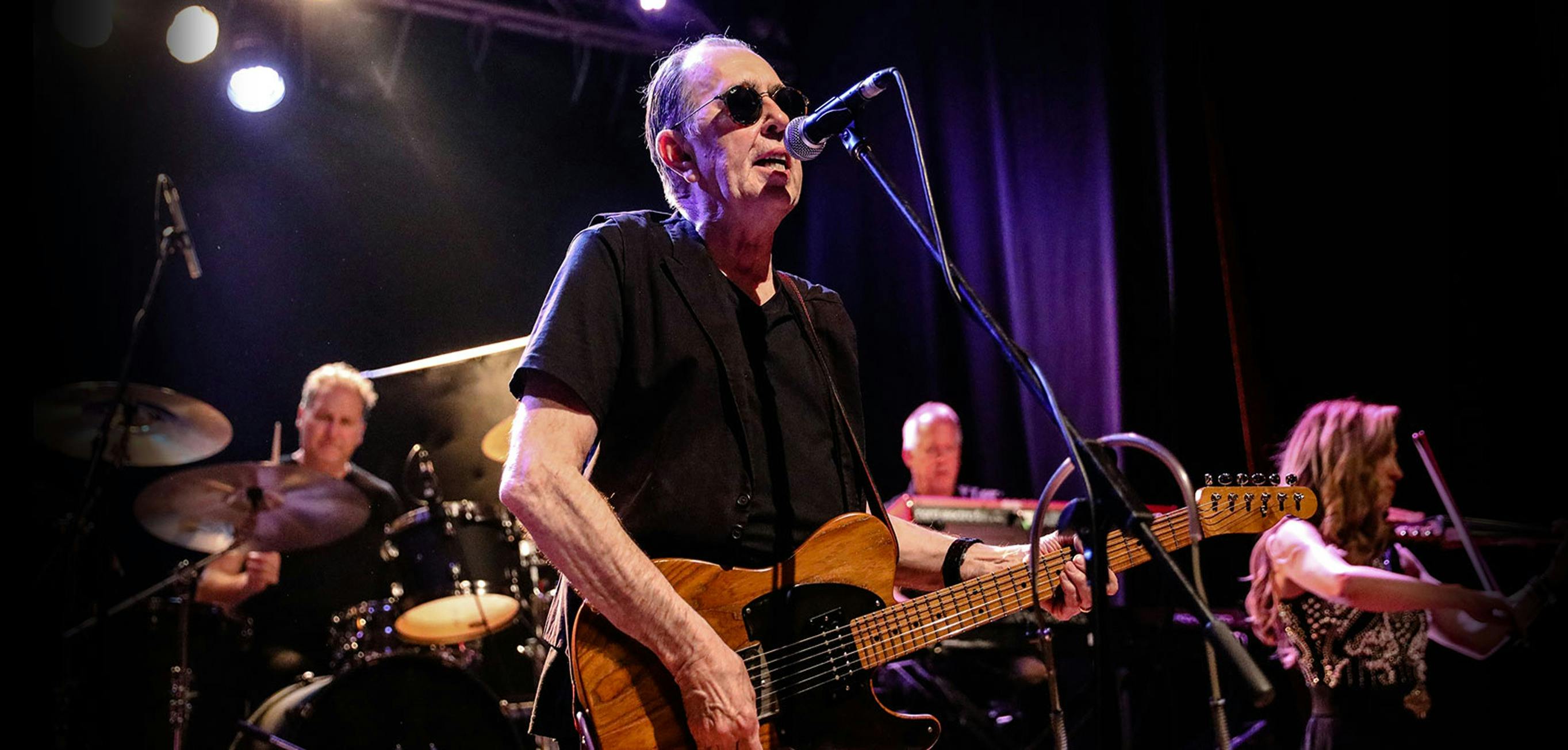 David Surkamp singing and playing guitar during a Pavlov’s Dog concert