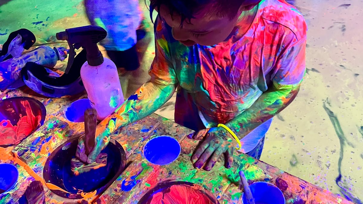 A child mixing paints in the giant 200cm paint palette
