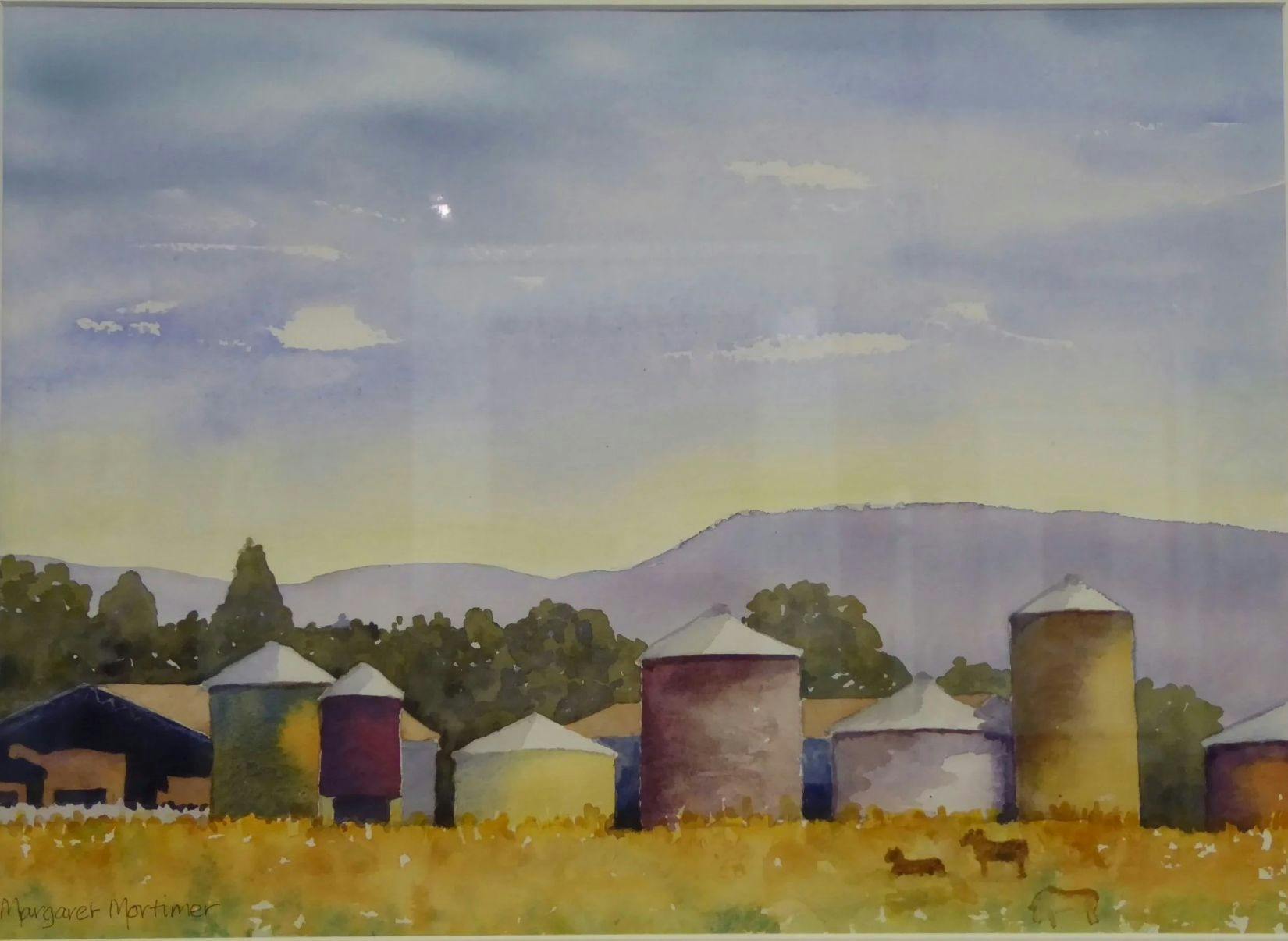 A scene of silos, trees, paddocks and distant mountains by Margaret Mortimer.
