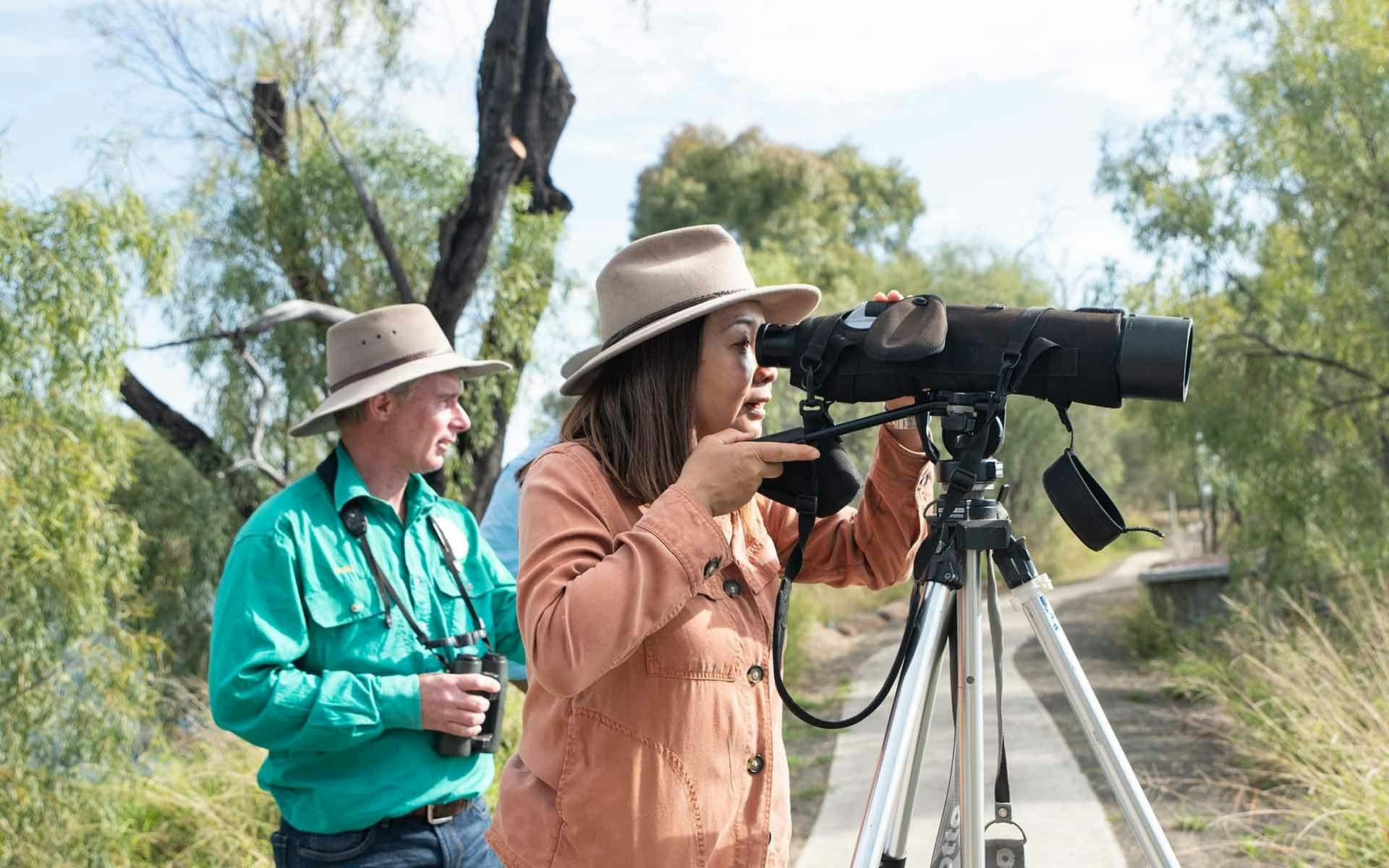 Two people birdwatching using a scope