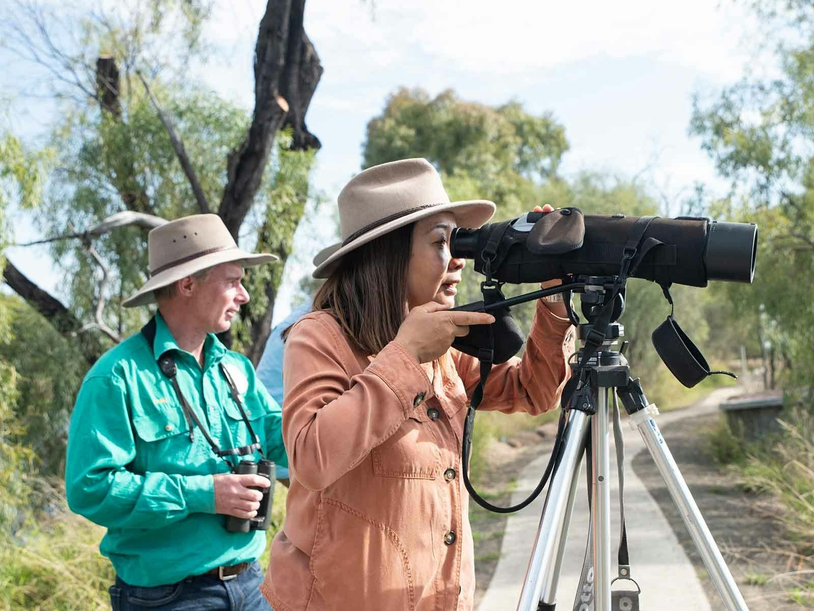 Two people birdwatching using a scope Two people birdwatching using a scope