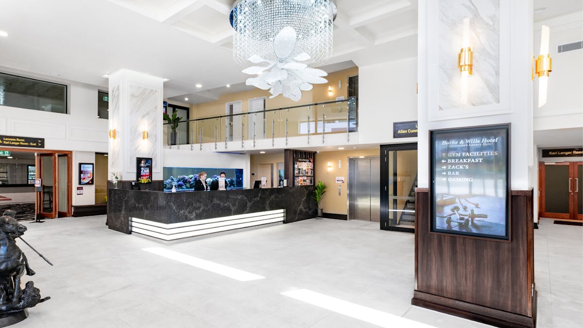 Burke & Wills Hotel foyer & reception featuring a crystal chandelier and 5m fish tank behind desk