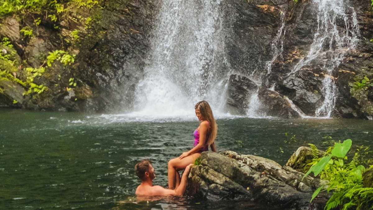 Couple in waterfall swimming hole