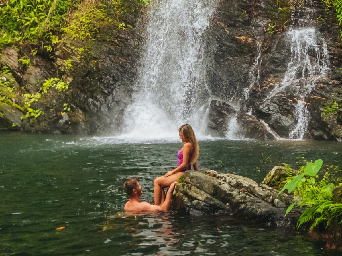 Couple in waterfall swimming hole