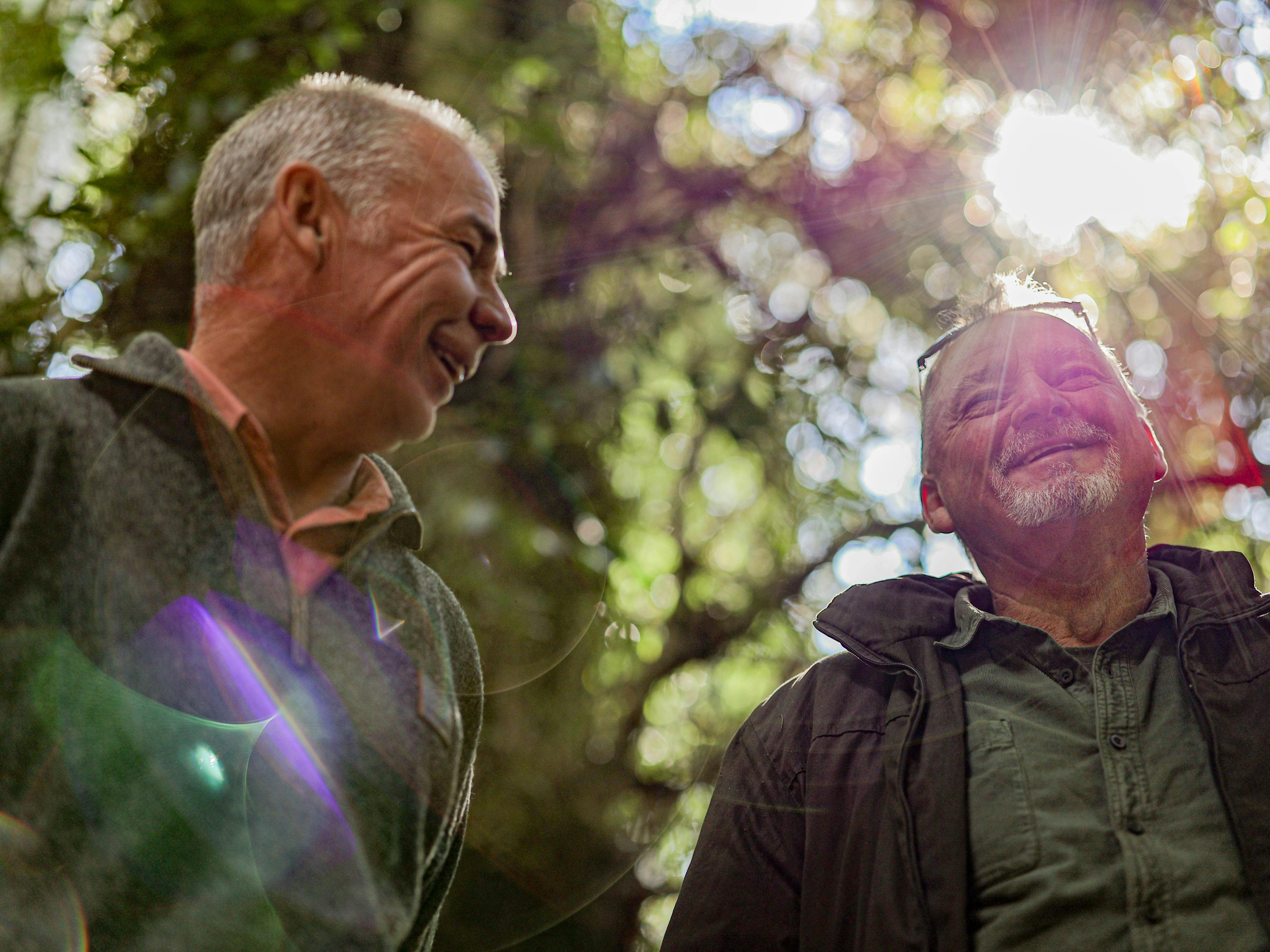 two men enjoying the foests with sun shinning through the canopy