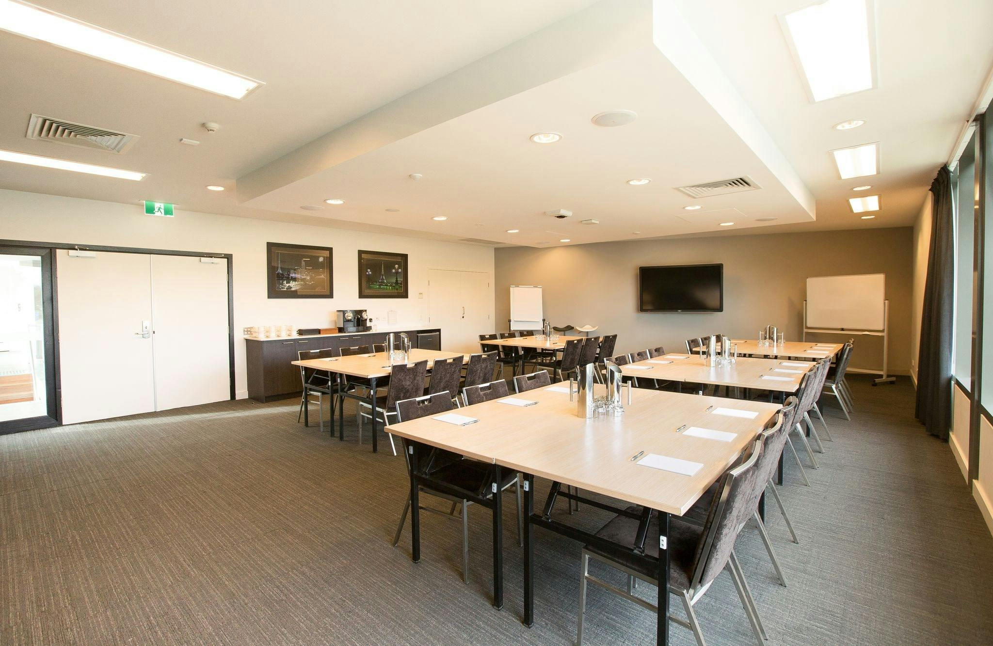 A wide shot of our Conference Room, with a tea and coffee station, tables, chairs and AV equipment