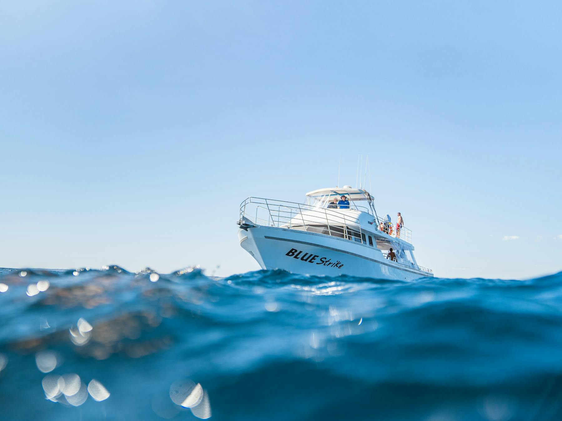 A boat floats on the water in the sunshine