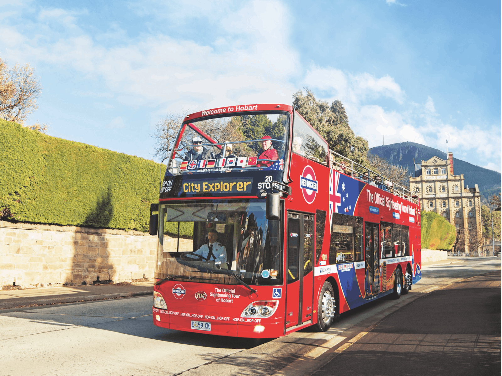 Red double decker bus with Cascade Brewery and kunanyi/Mt Wellington in the background.
