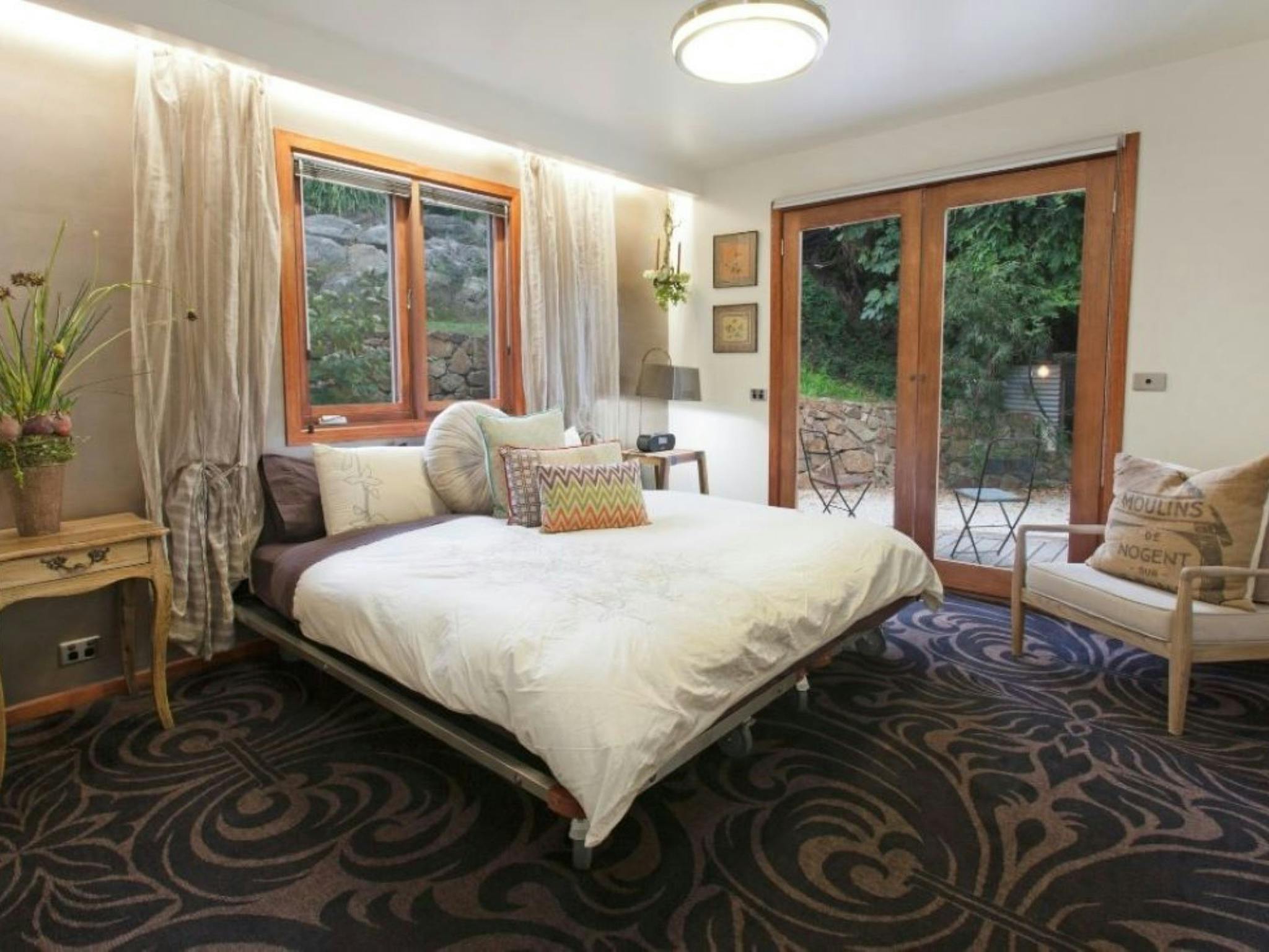 The ground floor bedroom opens directly onto the timber deck and has views to the garden and stream.