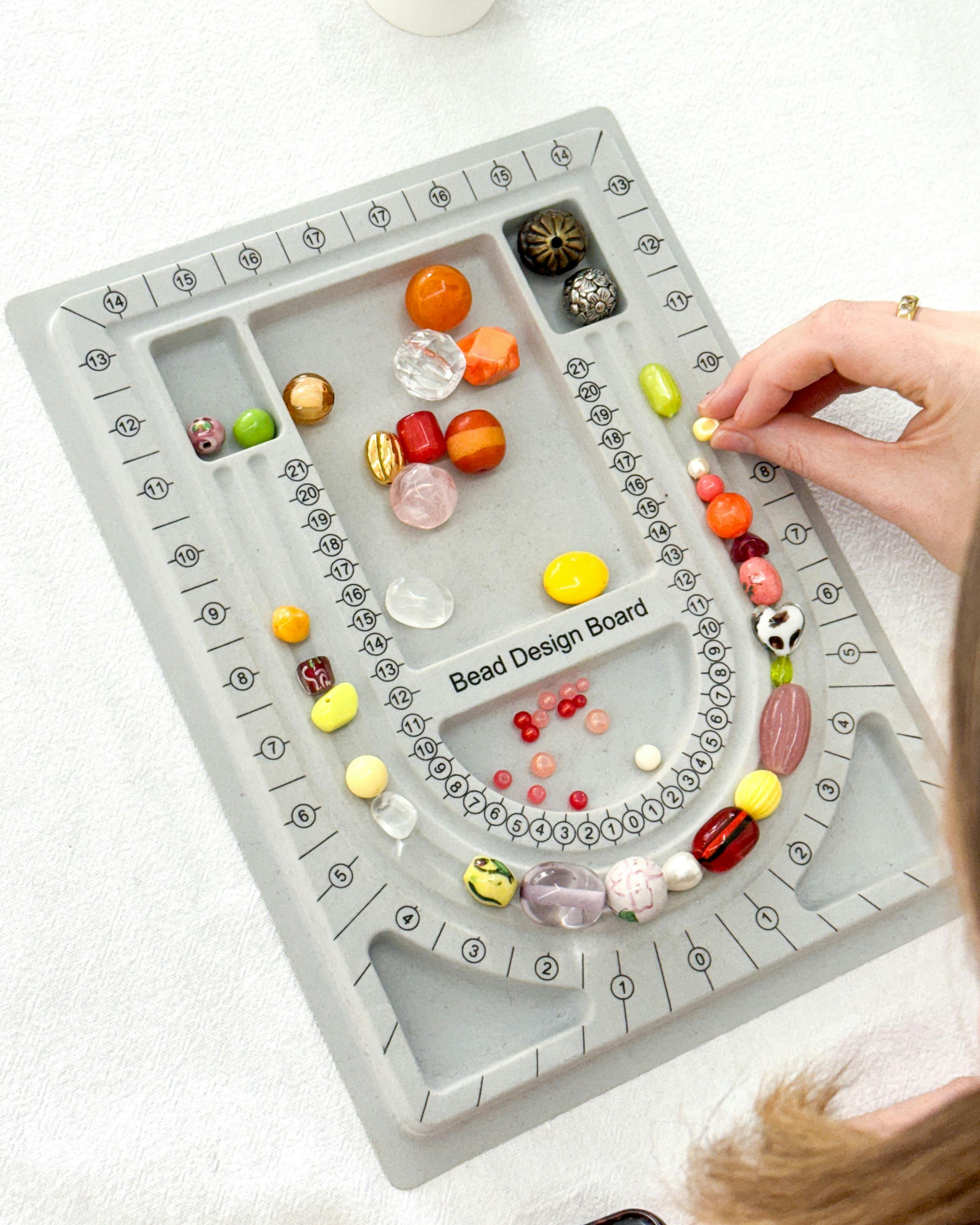 Table covered in plastic containers that hold an array of colourful beads