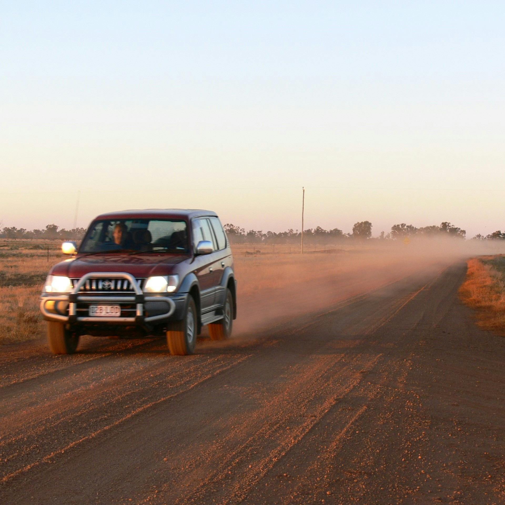 4WD car driving on dirt road