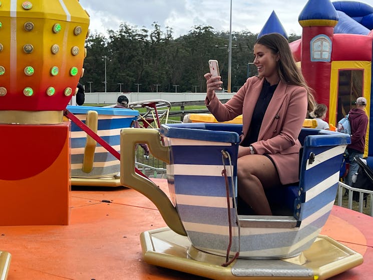 Woman on spinning cup amusement ride