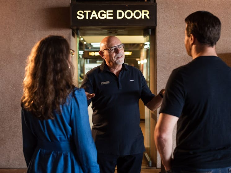 Tour guide and tour patrons standing at Stage Door