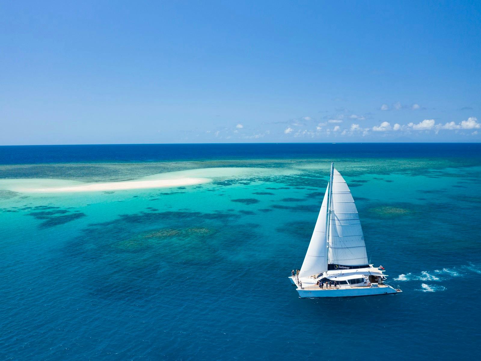 Sailaway VII in full sail with Mackay Cay as backdrop
