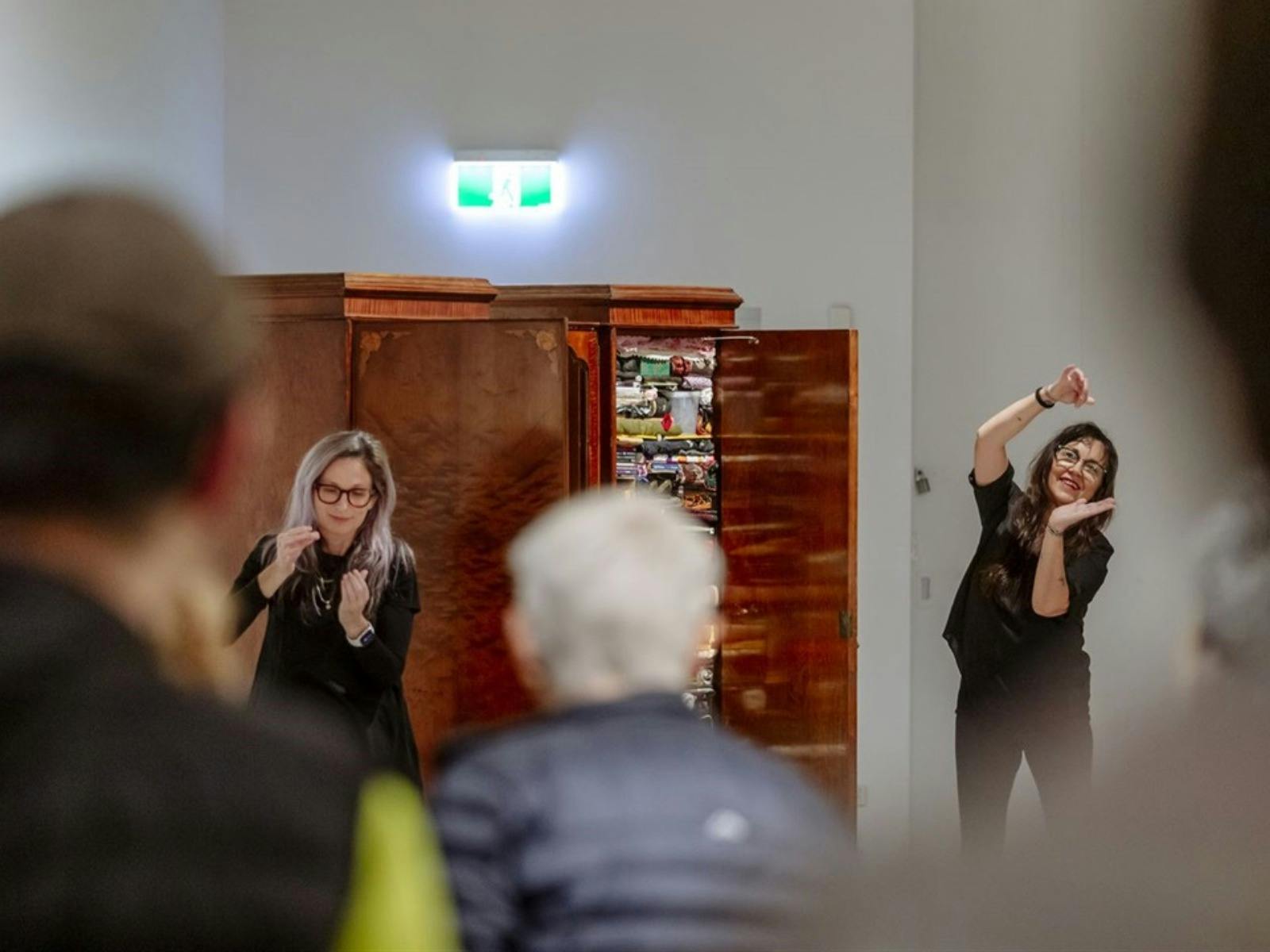 Gesture tour facilitators at CAC with their hands up in front of an art installation.