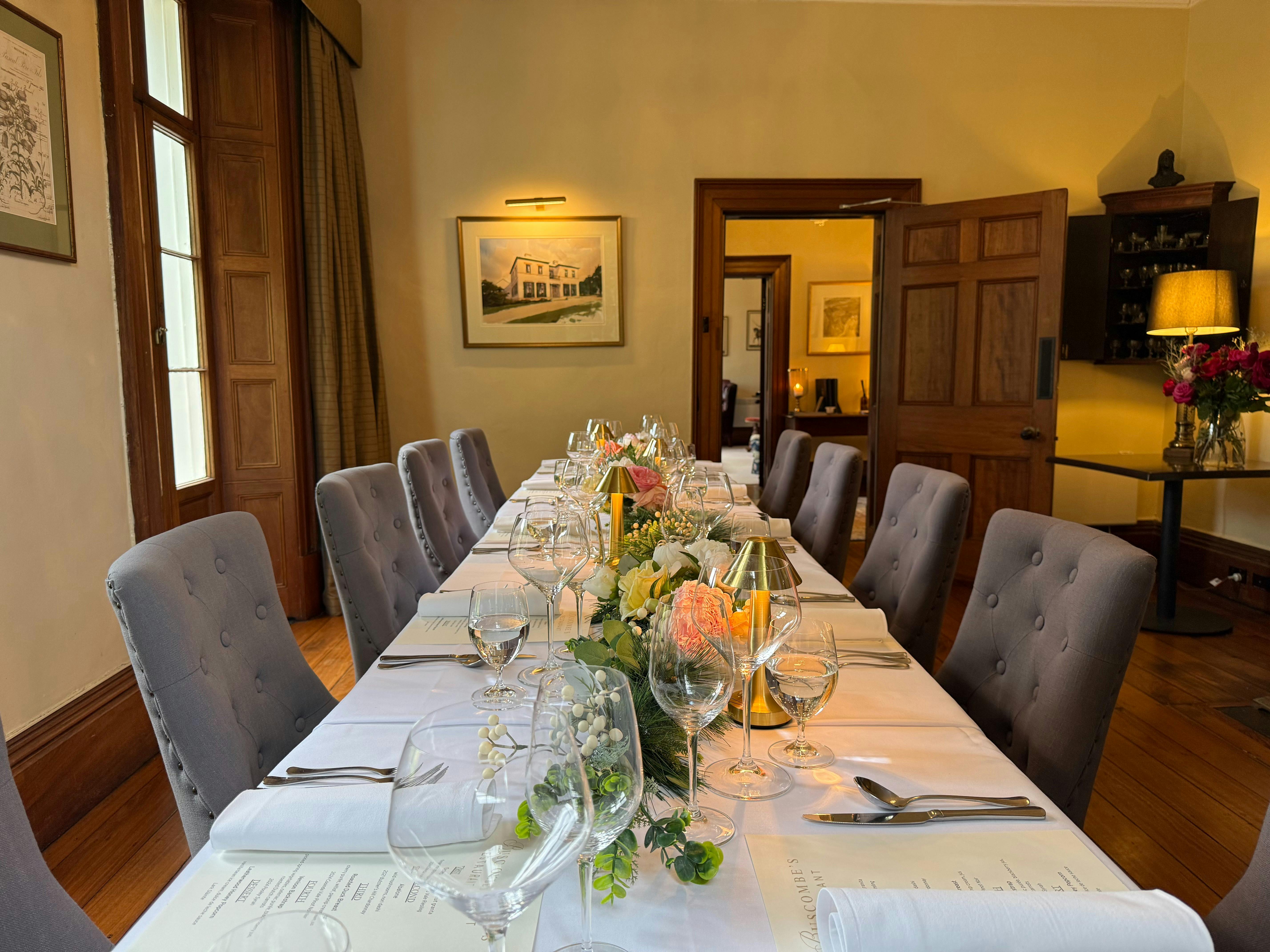 an longtable decorated with flowers, napkins and cutlery set for dinnerd