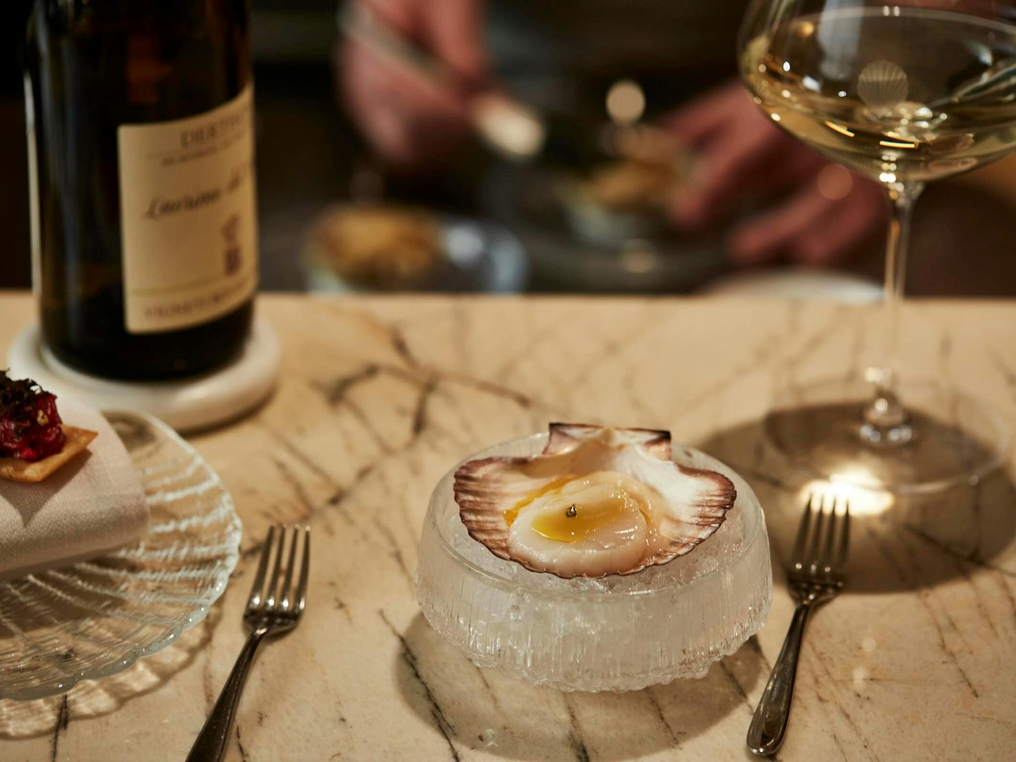 Scallop dish and wine on the kitchen pass