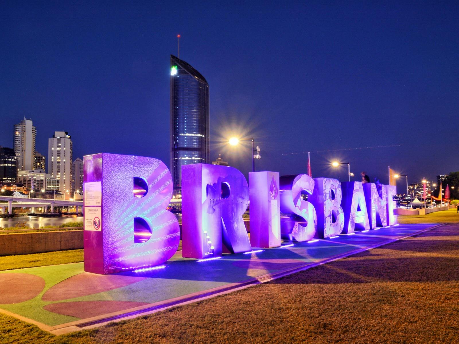 夜間，發光的「布里斯班」標誌在城市天際線上發出紫色燈光
