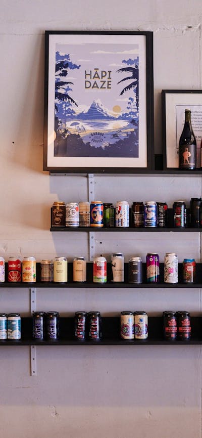 Wall shelf with beer tins sitting on it