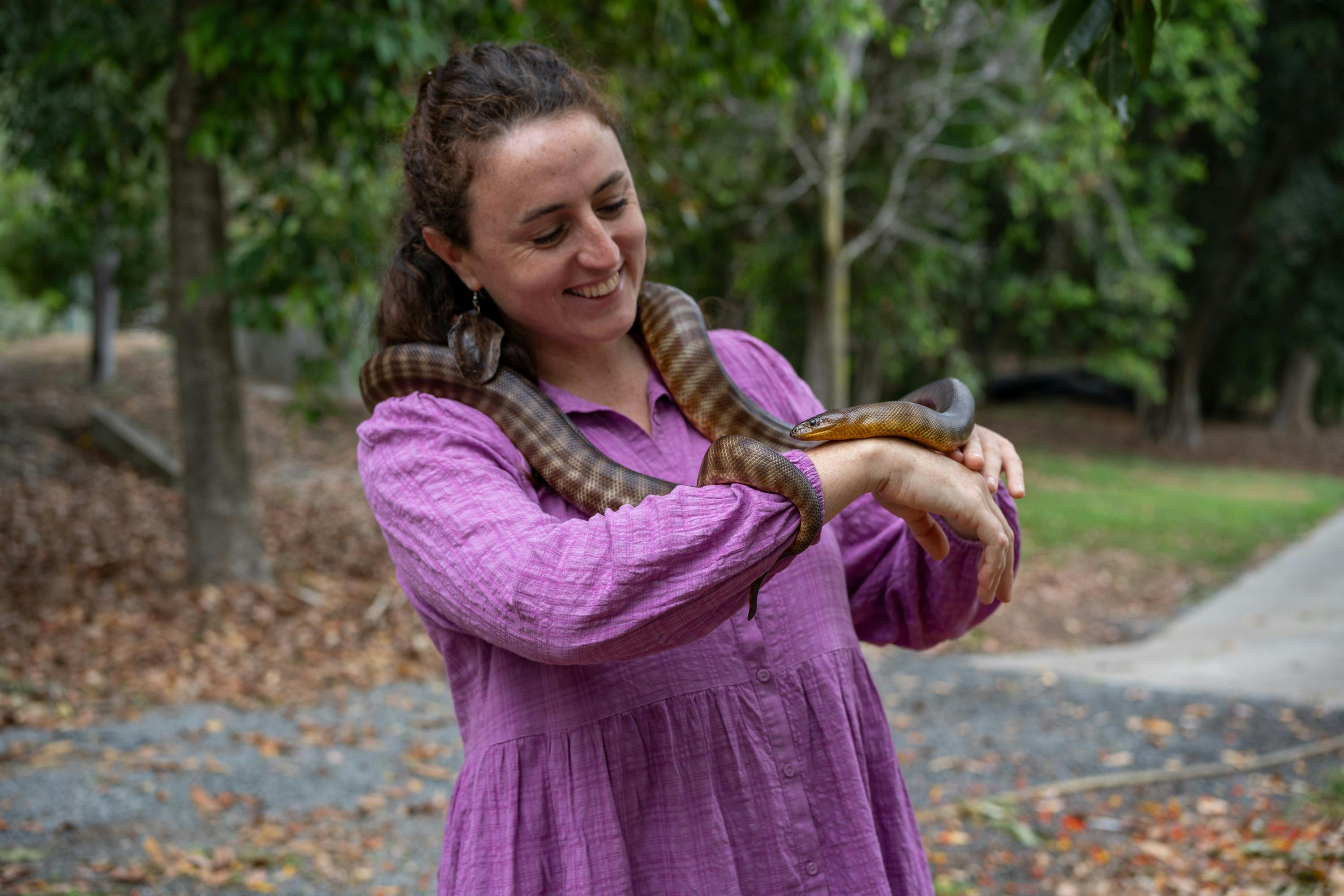 A young girl holding a snake as part of a snake encounter