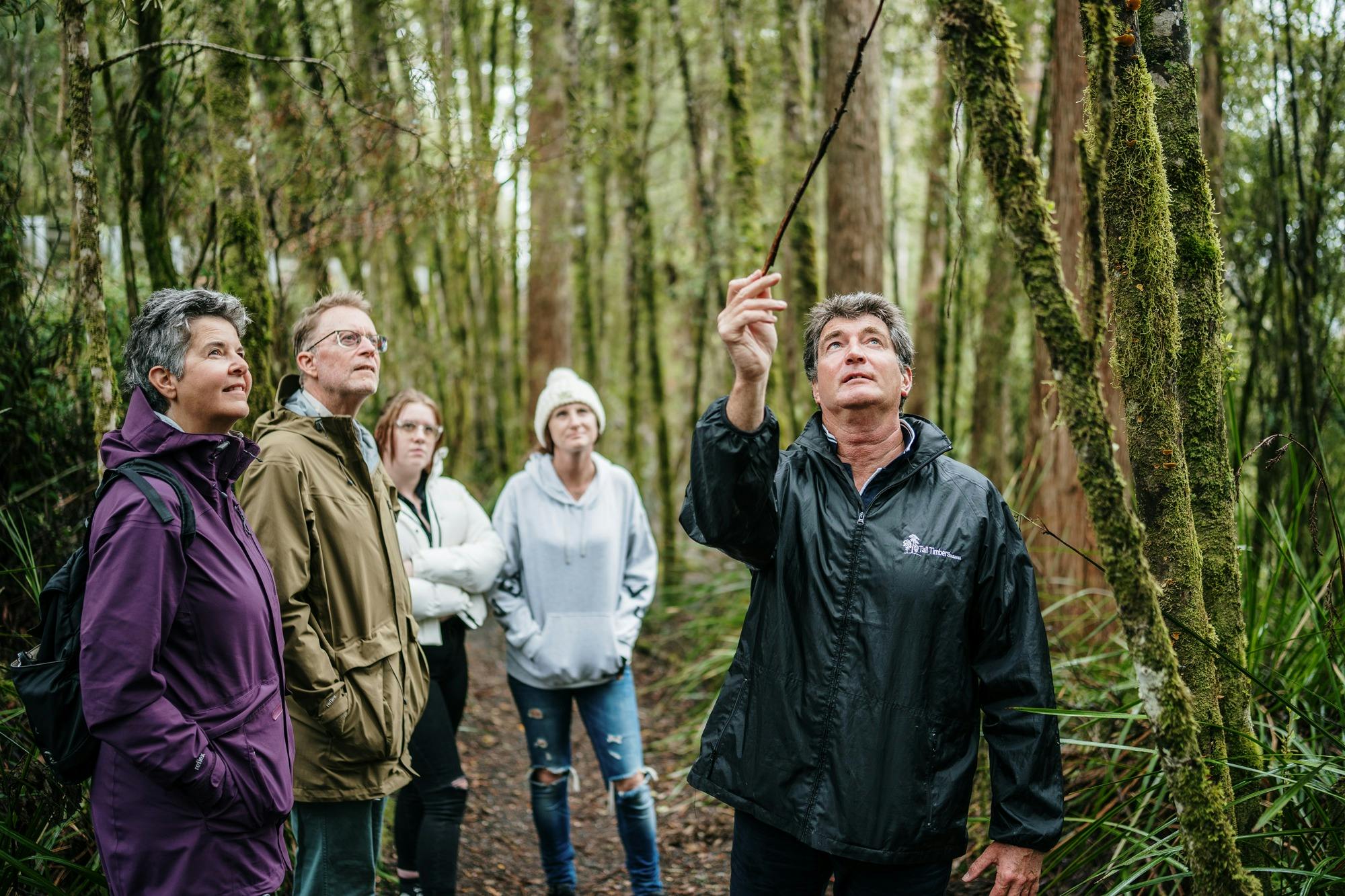 Expert tour guide Rob pointing out a unique orchid to a tour group