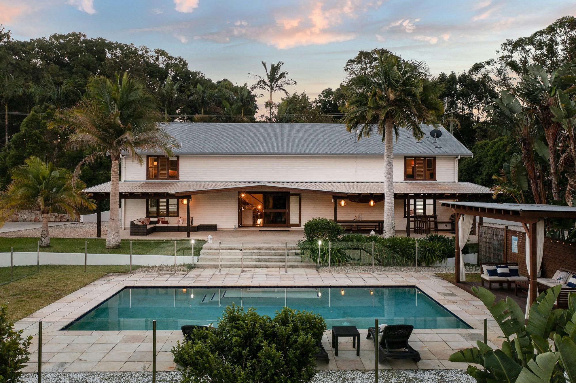 Wide glass doors open from the living area to a saltwater pool, BBQ, and entertaining patio