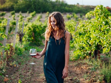 Enjoying a glass of wine strolling in the vineyard Enjoying a glass of wine strolling in the vineyard