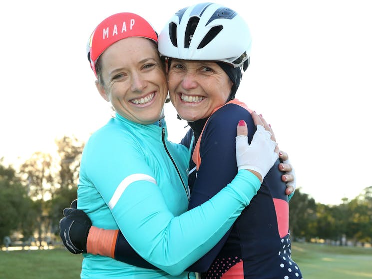 Two cyclists celebratory hug