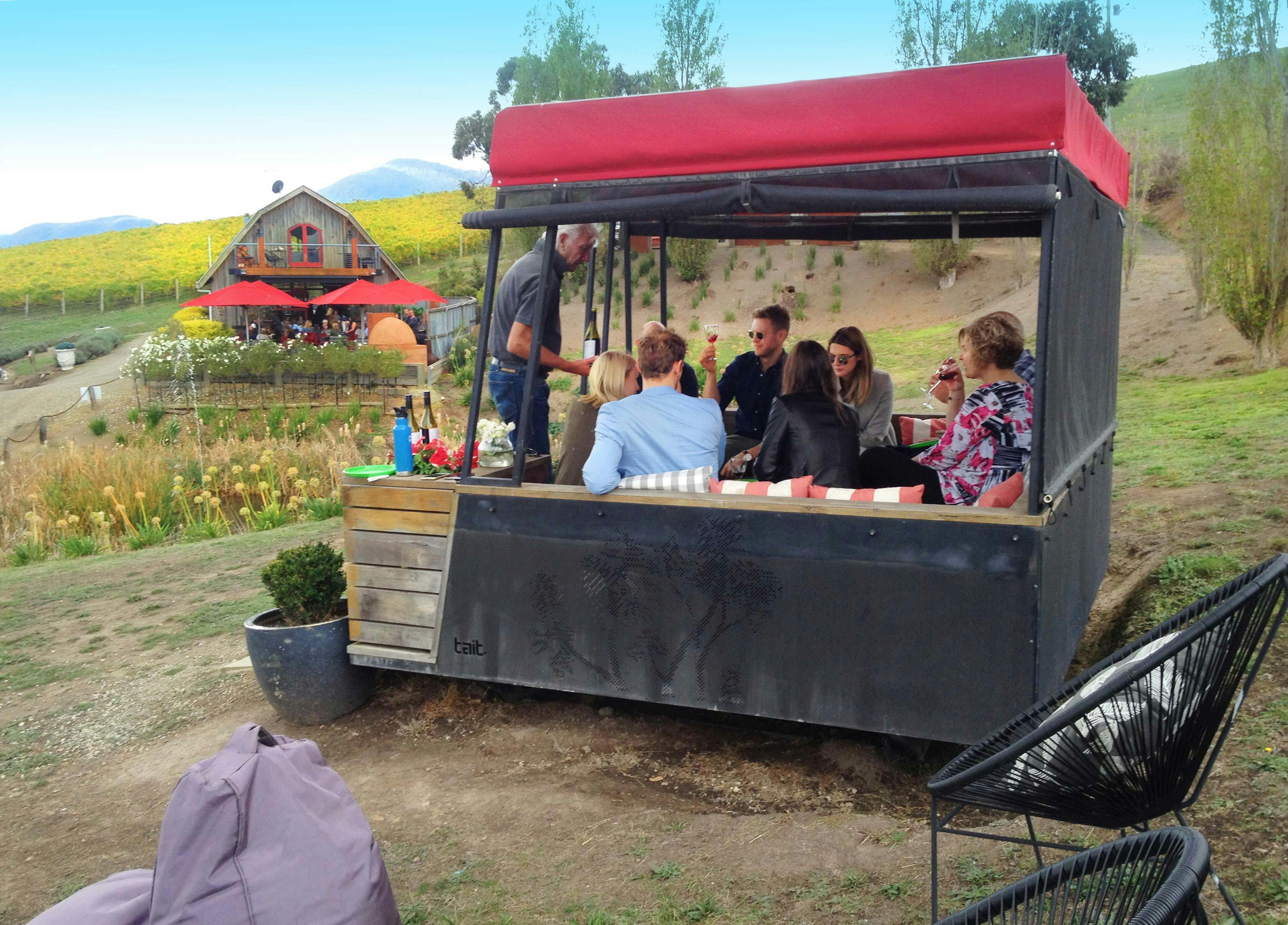 Family group having lunch with the wine maker in an outdoor gazebo