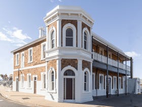 Front view of the Pastoral Hotel Motelu2019s heritage main building with intricate ironwork detail