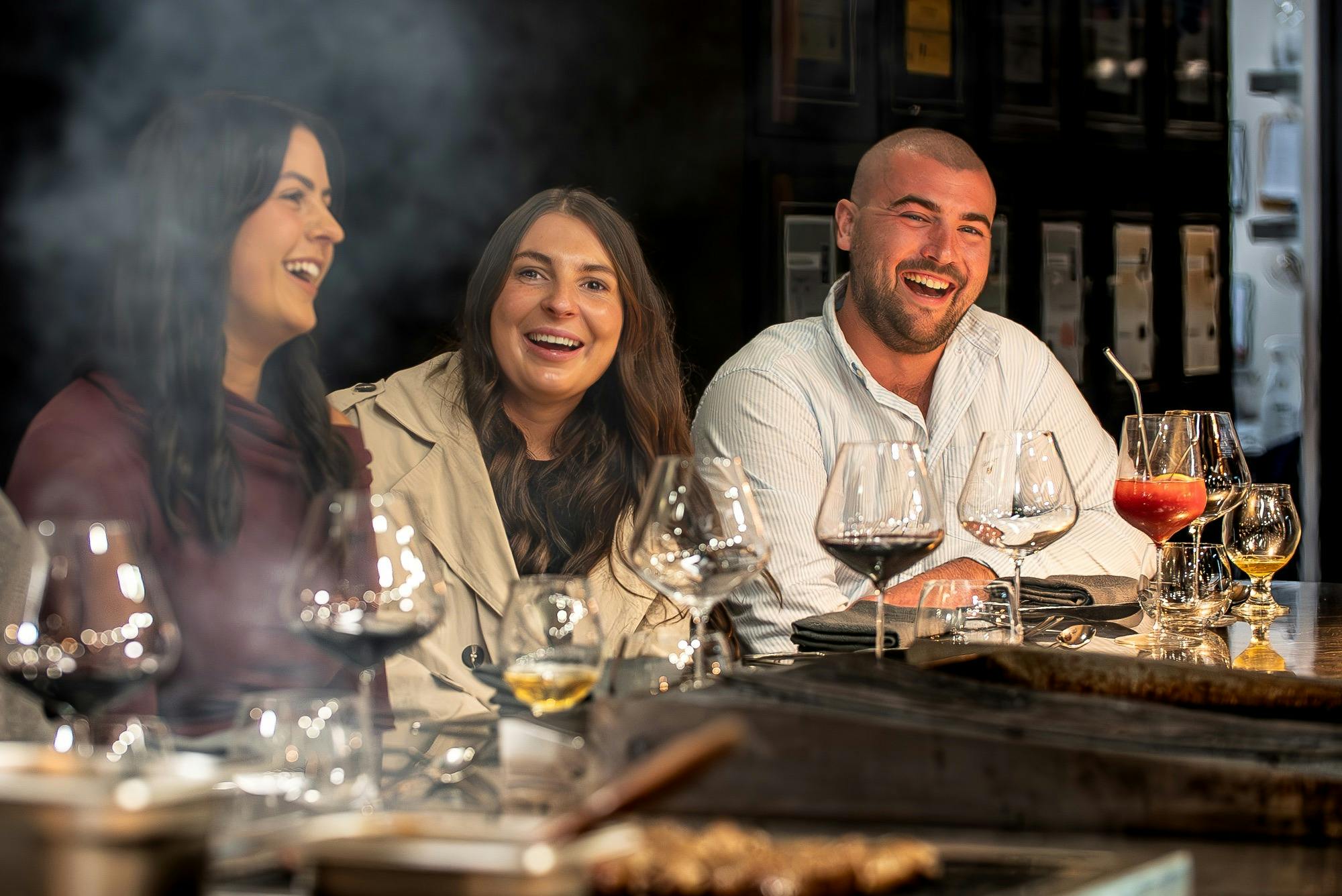 Three guests seated together over dinner and wine at Mayura Wagyu Steakhouse.
