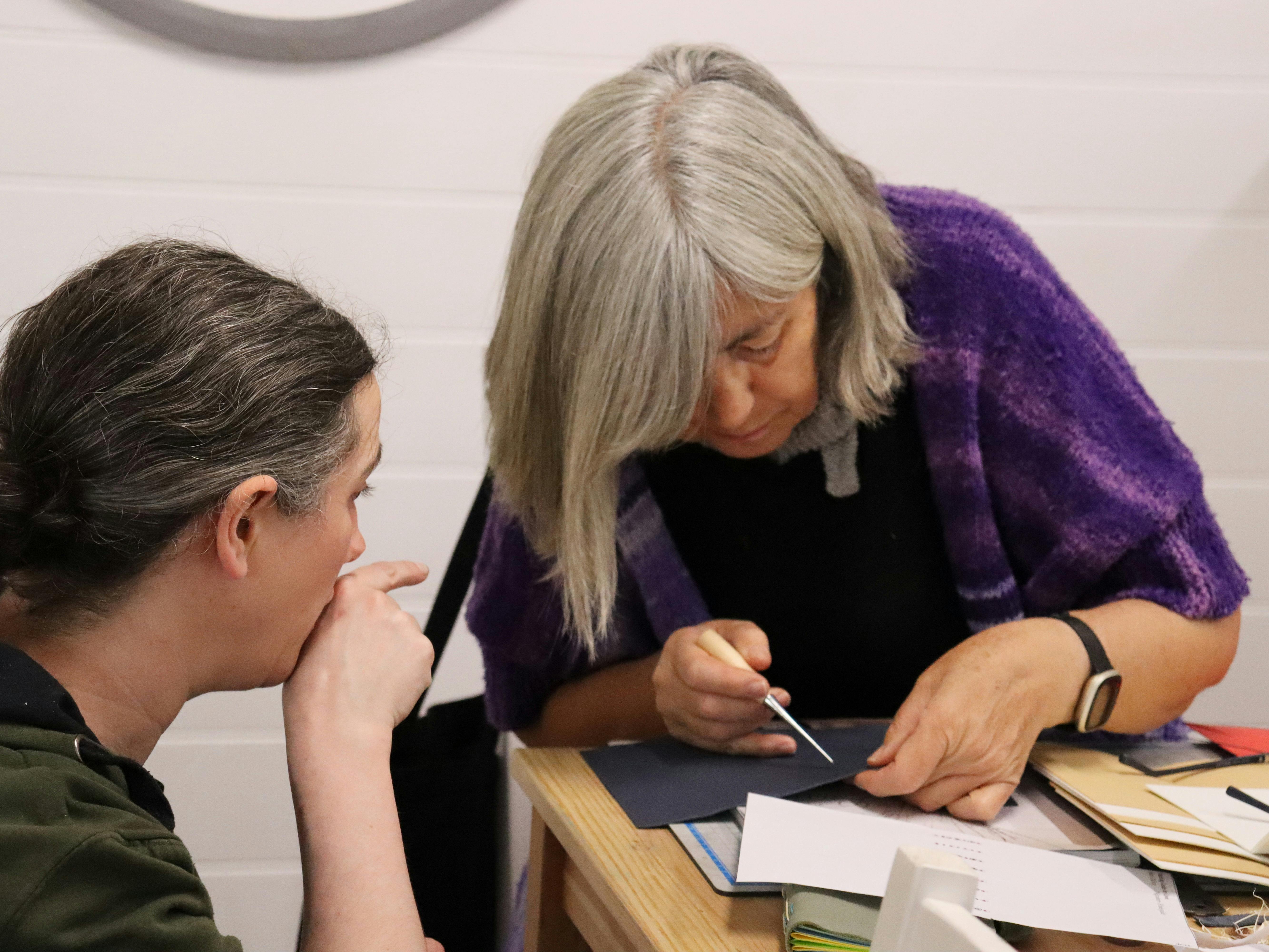 A student getting help with their leather journal