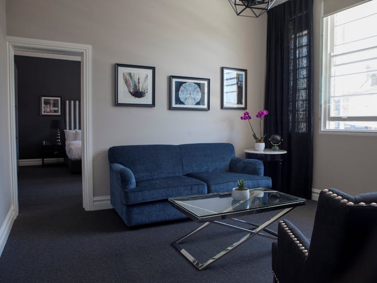 Grand Heritage Suite showing sitting room with bedroom in background.