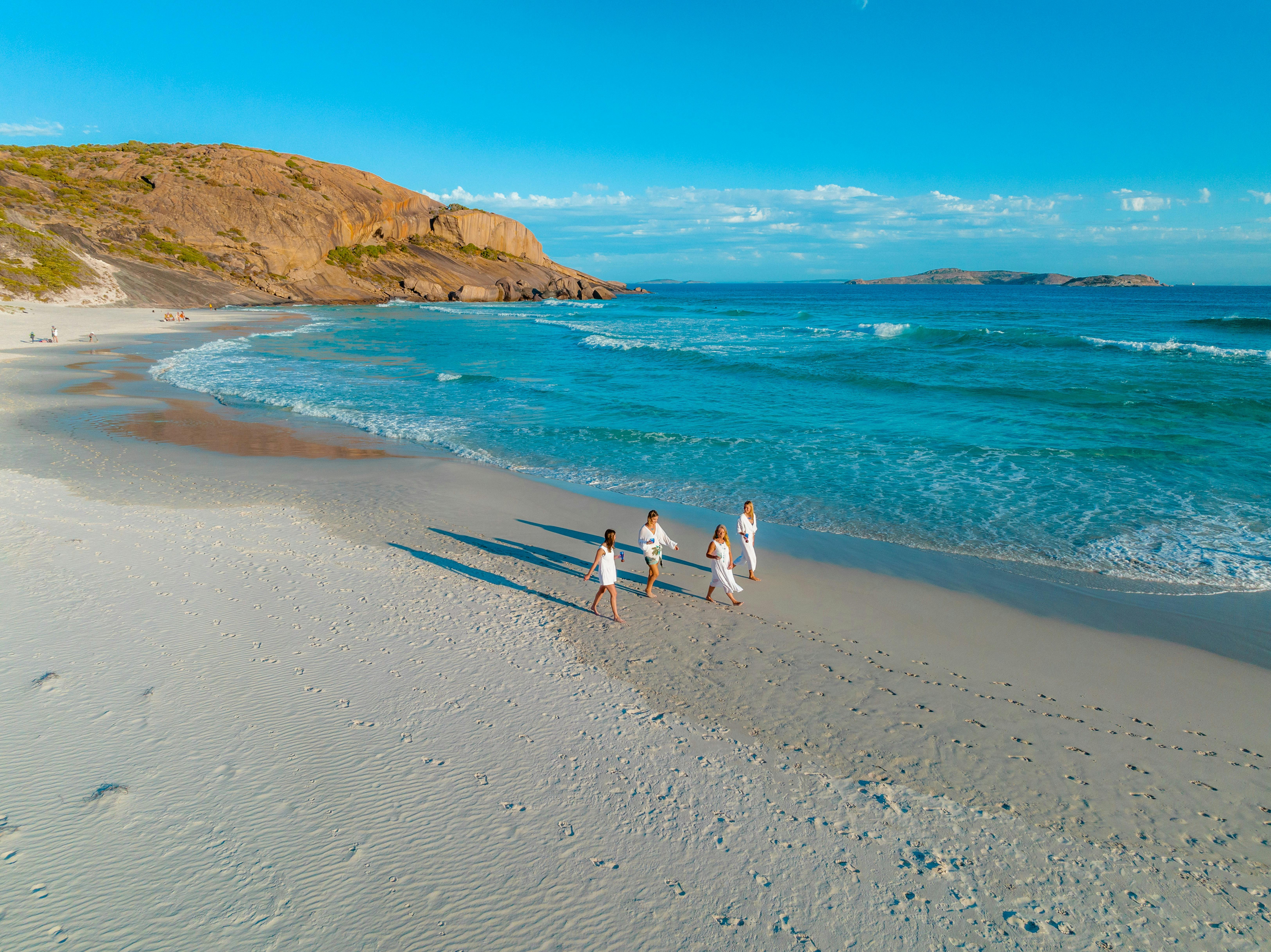 drone shot of people walking on west beach