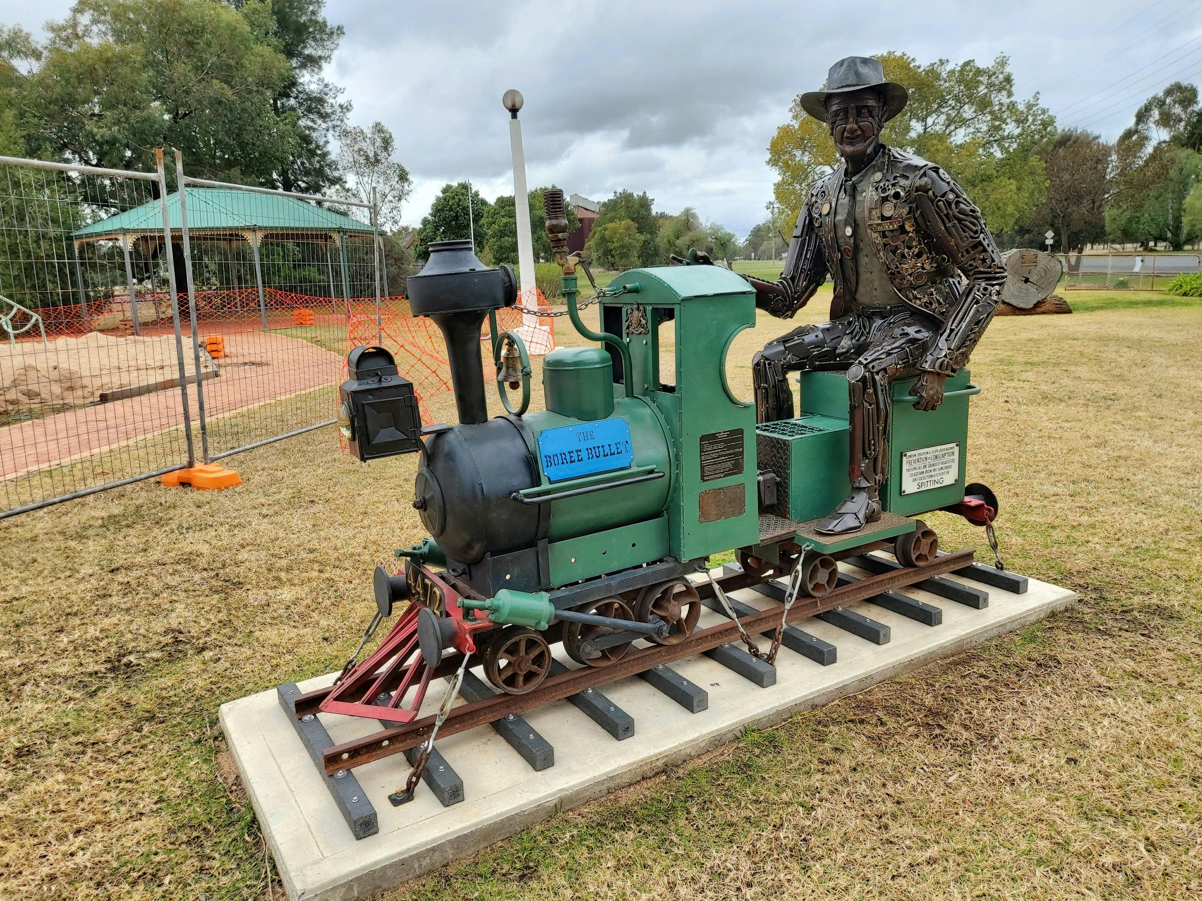 A metal sculpture of Tim Fischer riding a small train at Boree Creek