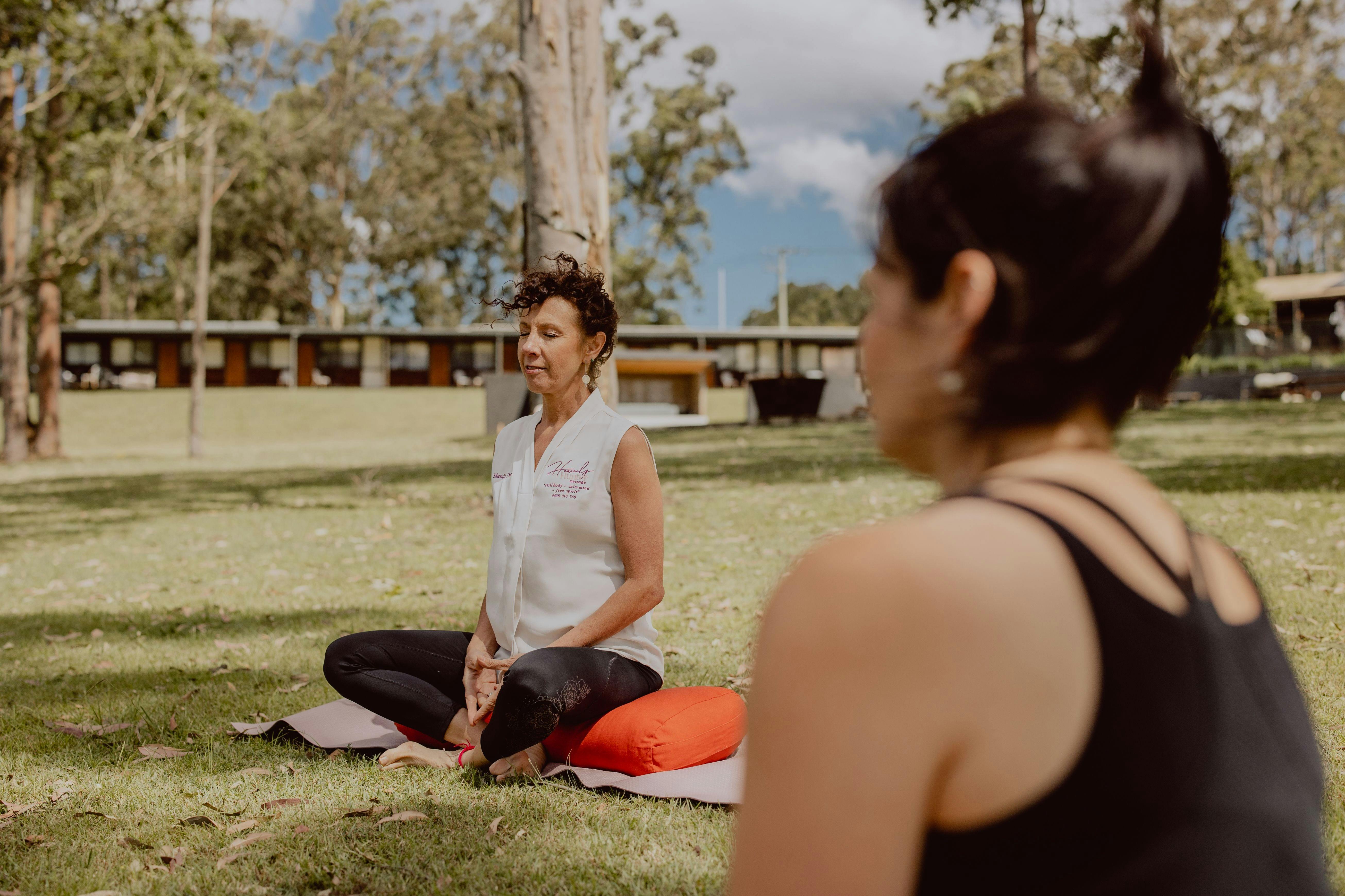 Two women sitting on the grass