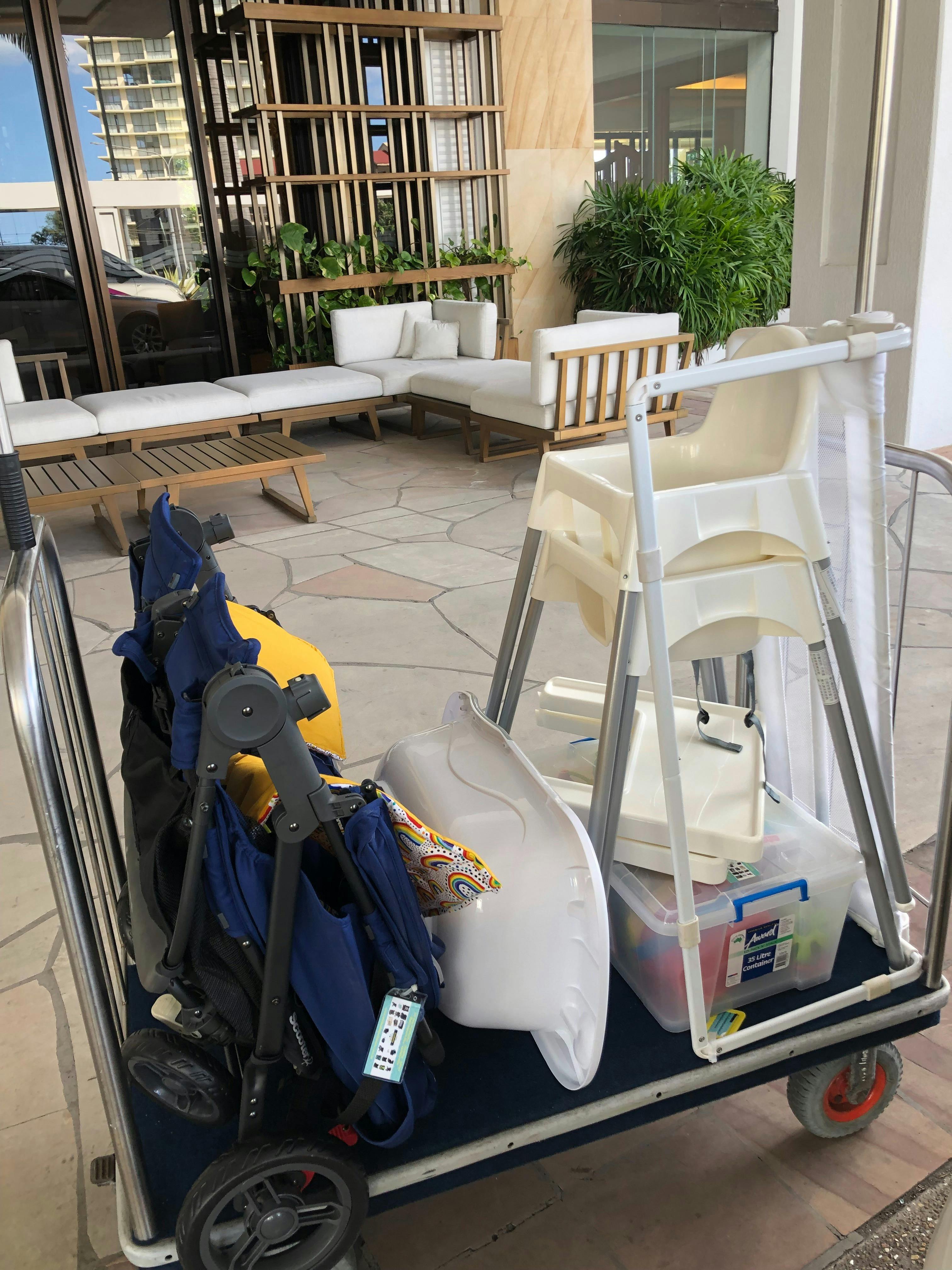 A pram, high chair and other baby gear on a luggage trolley at the  Marriott.