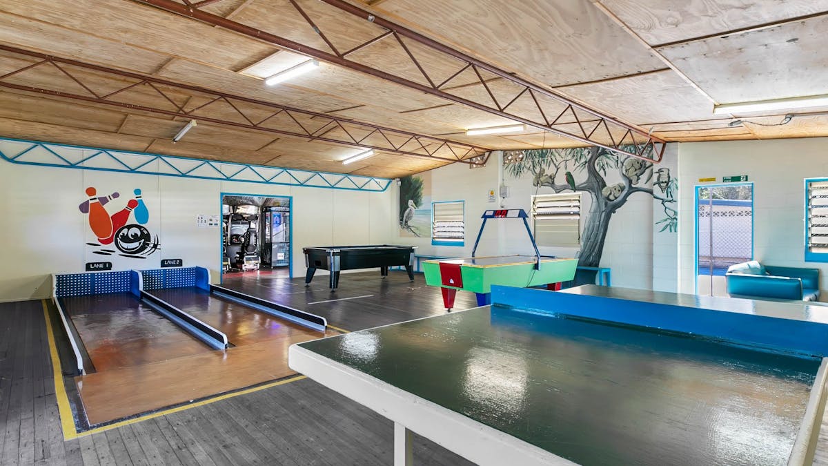 Indoor games room including a ping pong table, air hocky table, mini-bowling ally and more.