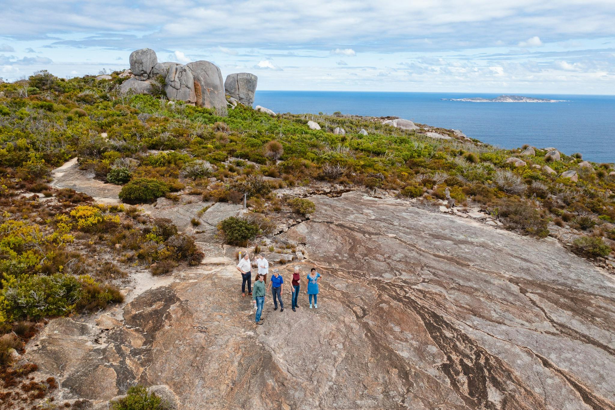 granite hill in bushland and people on nature trail