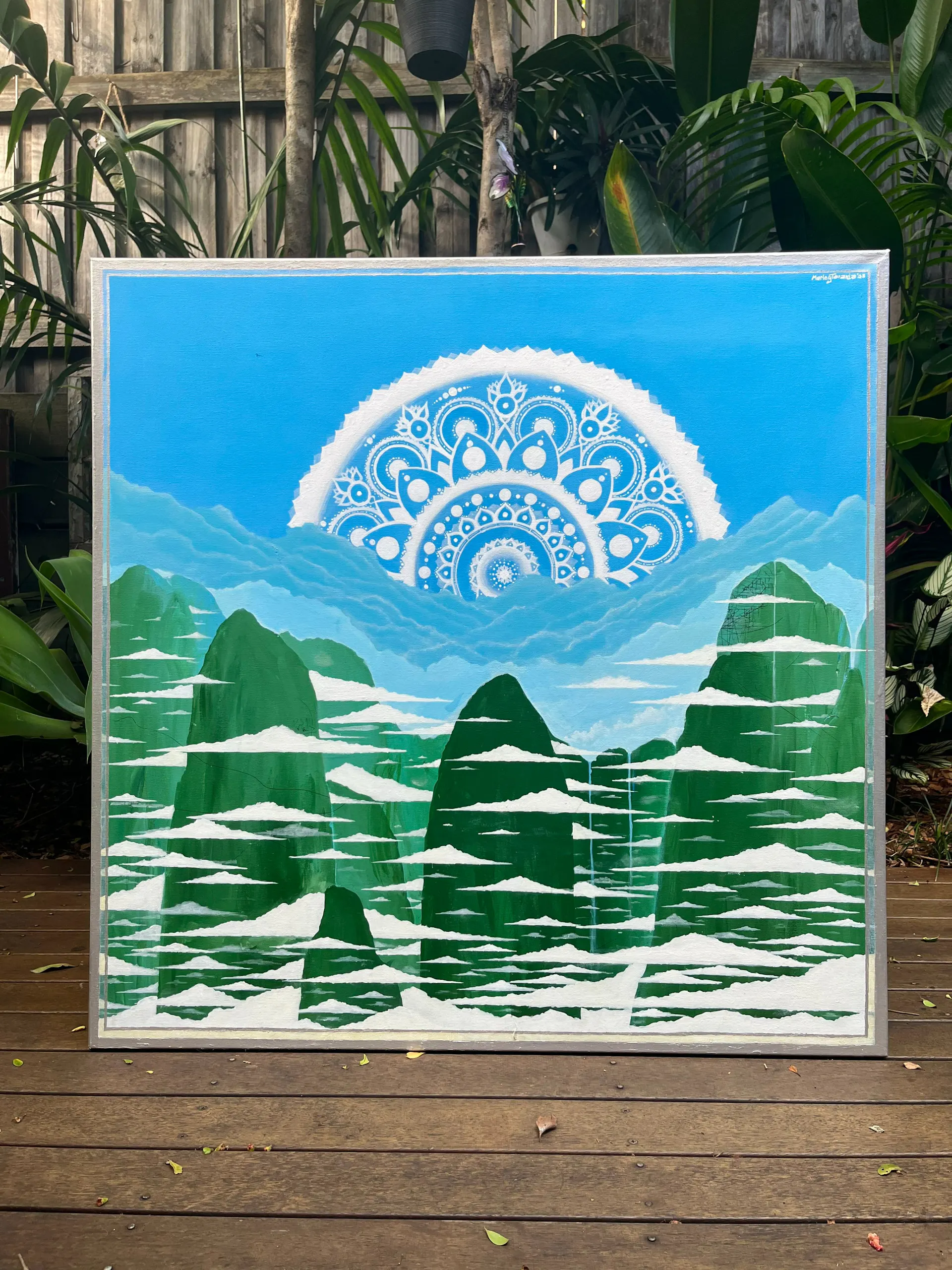 Painting of mountain landscape with mandala in the sky