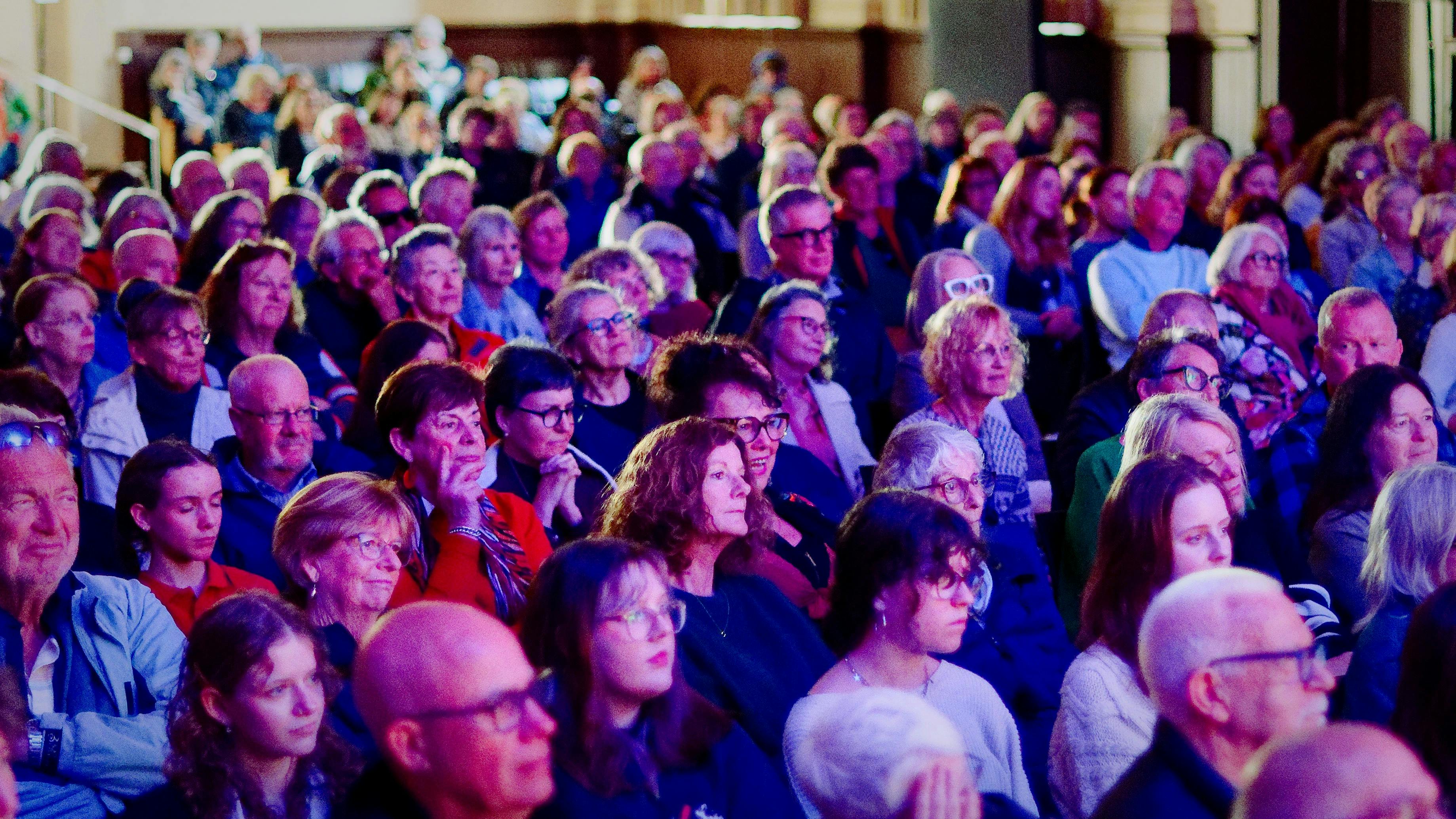 Audience members at QLF 2025 watch an event from the Queenscliff Town Hall.